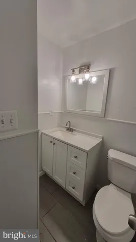 a bathroom with a toilet a sink a vanity and mirror