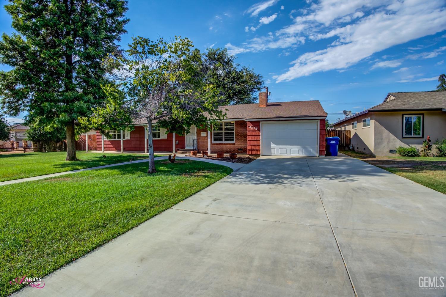 a view of a house with a yard and tree s