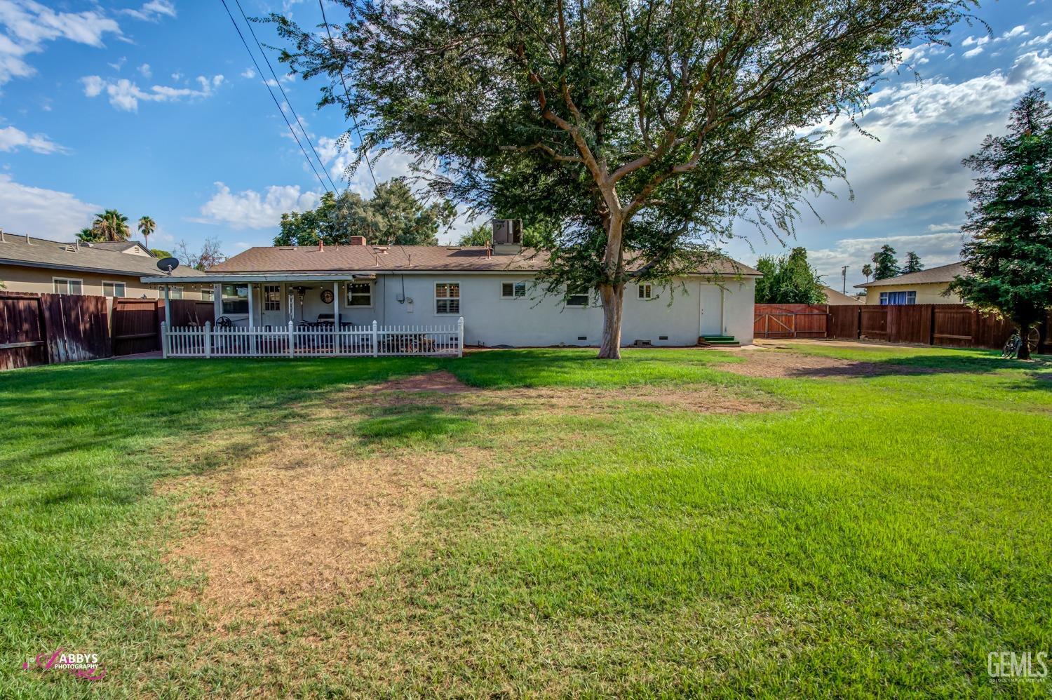 Undisclosed Address Bakersfield, CA 93309 - Photo 11 of 33 front view of a house with a yard and large trees
