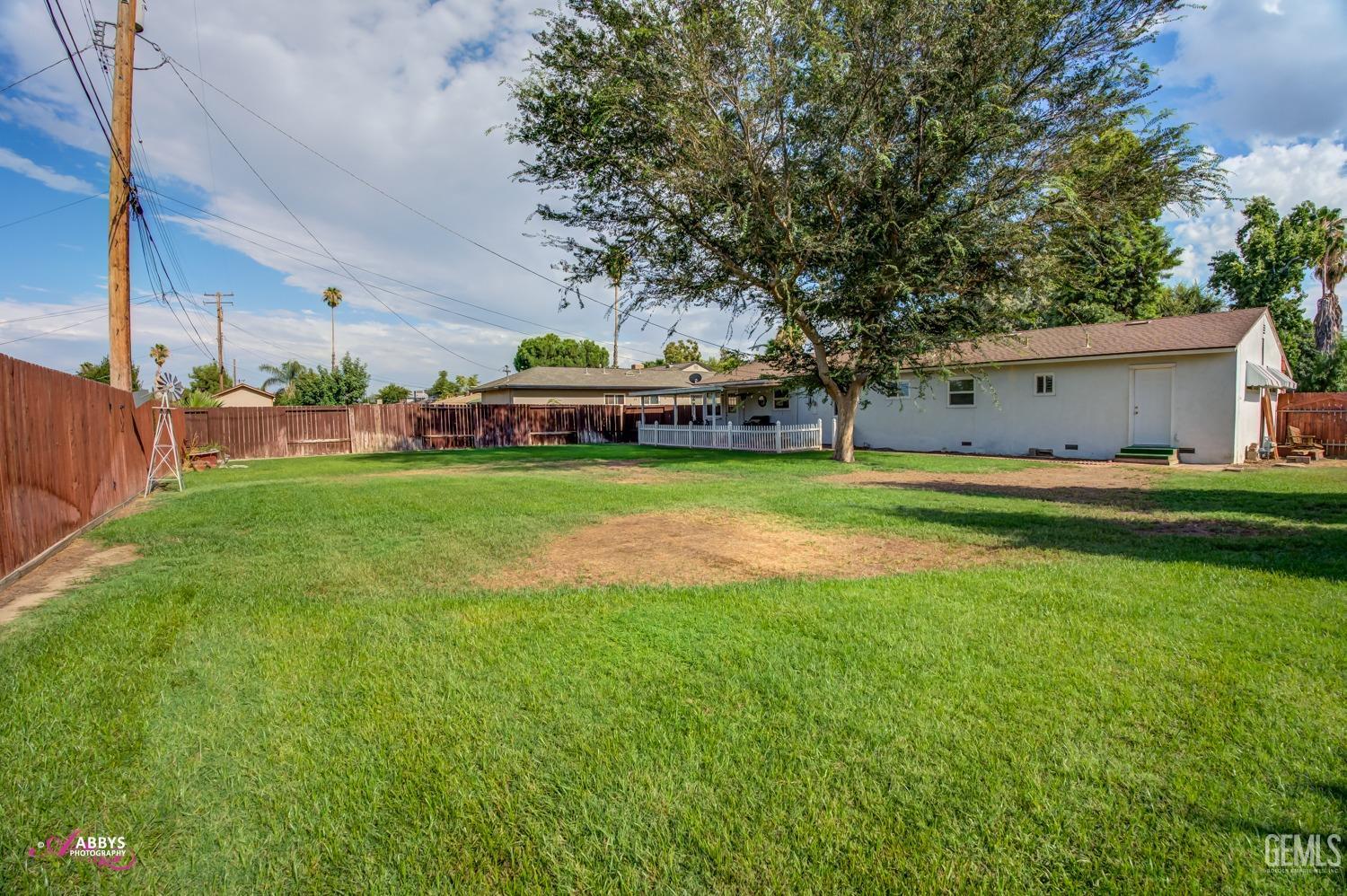 Undisclosed Address Bakersfield, CA 93309 - Photo 12 of 33 a view of a house with a big yard and large trees