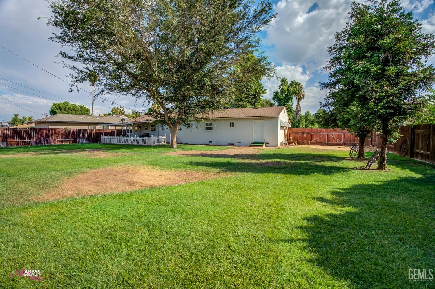 Undisclosed Address Bakersfield, CA 93309 - Photo 13 of 33 a view of a house with a big yard and large trees