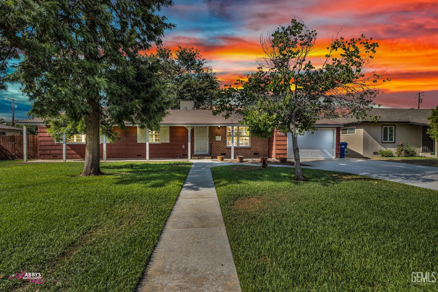 Undisclosed Address Bakersfield, CA 93309 - Photo 2 of 33 a front view of a house with a yard and trees