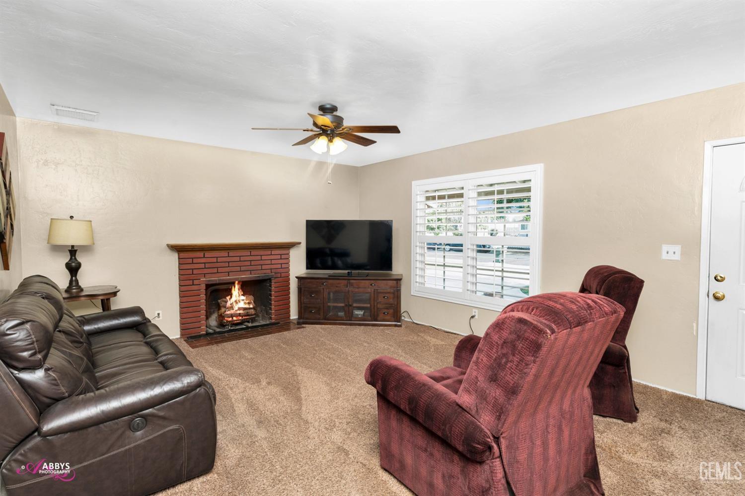 Undisclosed Address Bakersfield, CA 93309 - Photo 25 of 33 a living room with furniture a flat screen tv and a fireplace