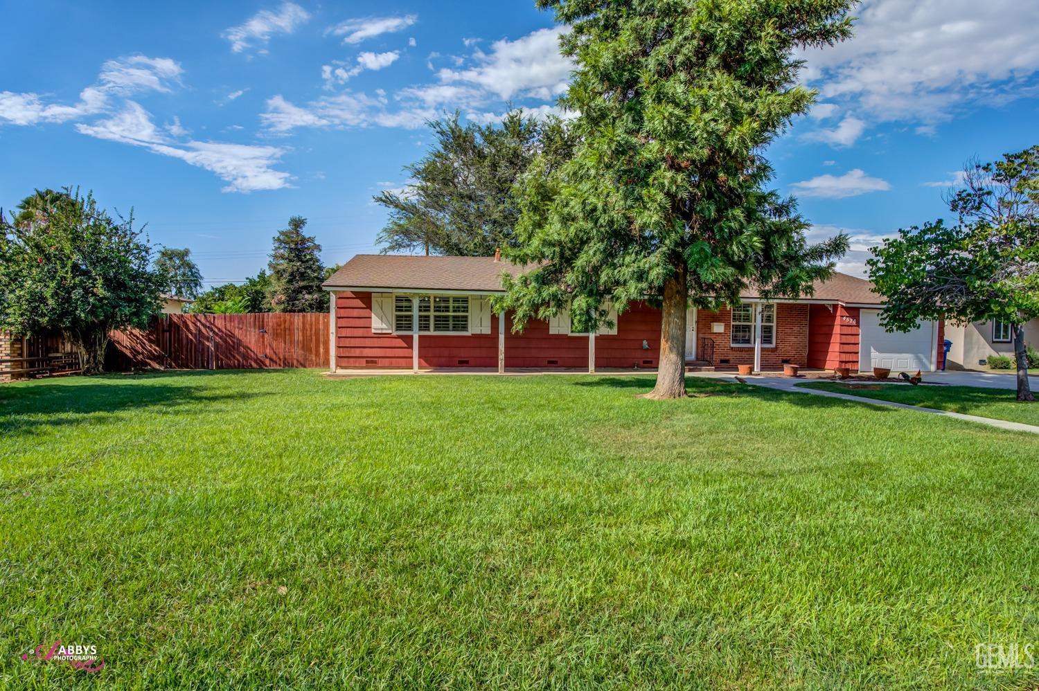 Undisclosed Address Bakersfield, CA 93309 - Photo 5 of 33 a view of a house with a big yard and large tree