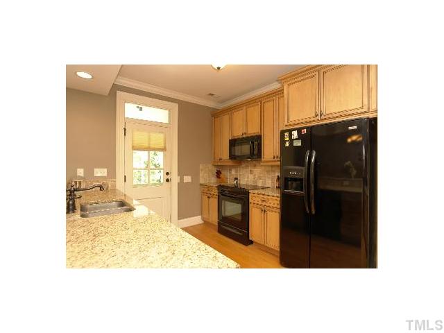 1115 Wake Forest Road, Unit D Raleigh, NC 27604 - Photo 3 of 24 a kitchen with a refrigerator and cabinets