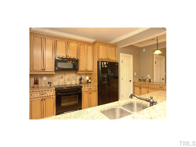 1115 Wake Forest Road, Unit D Raleigh, NC 27604 - Photo 4 of 24 a kitchen with kitchen island granite countertop a refrigerator stove top oven and sink