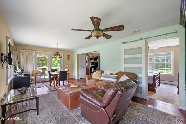 a living room with furniture ceiling fan and a window