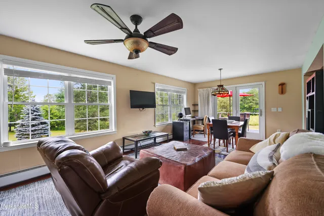 a living room with furniture a flat screen tv and a large window