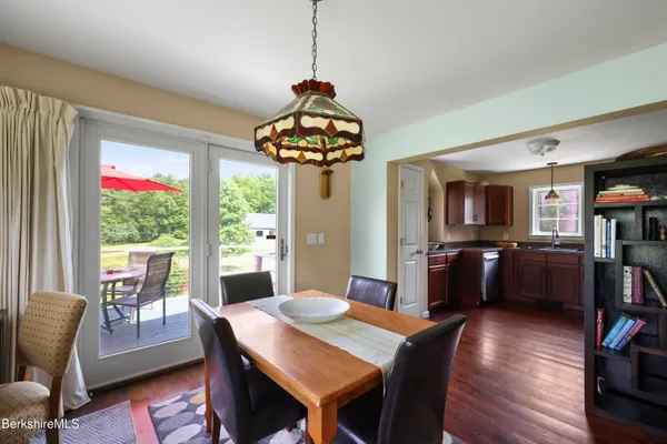 a dining room with furniture a chandelier and wooden floor