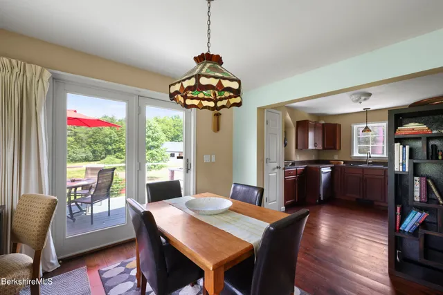 a dining room with furniture a chandelier and wooden floor