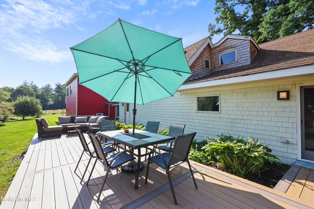 a view of deck with patio table and chairs under an umbrella