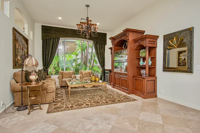 a dining room with wooden floor a chandelier a glass table and chairs