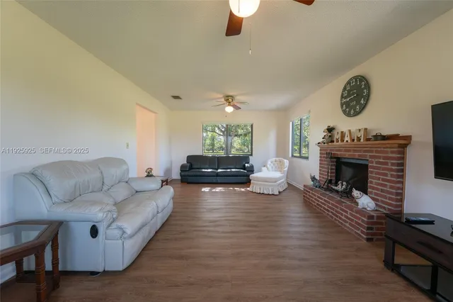 a living room with furniture a fireplace and a large mirror