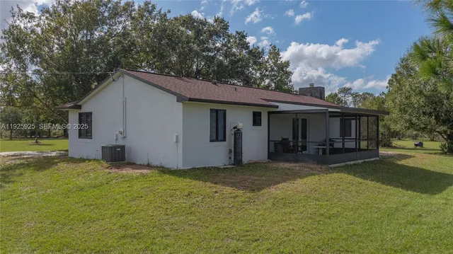 a view of a house with a yard and large tree