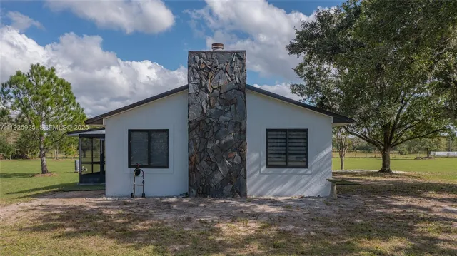 a view of a house with a yard and tree