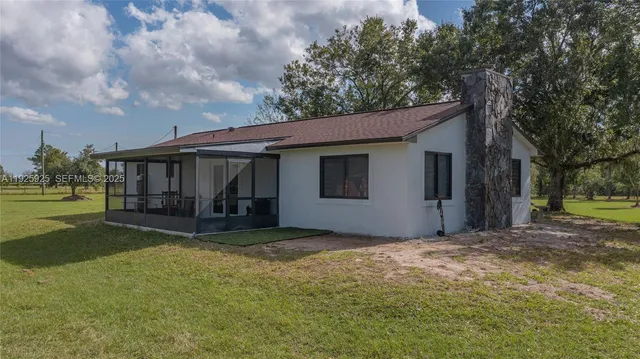 a view of a house with backyard and sitting area