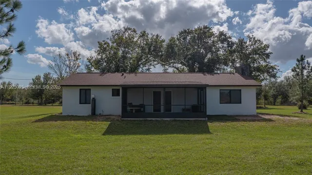 a view of a house with a yard potted plants and large tree