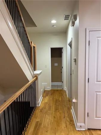 a view of a hallway with entryway and wooden floor