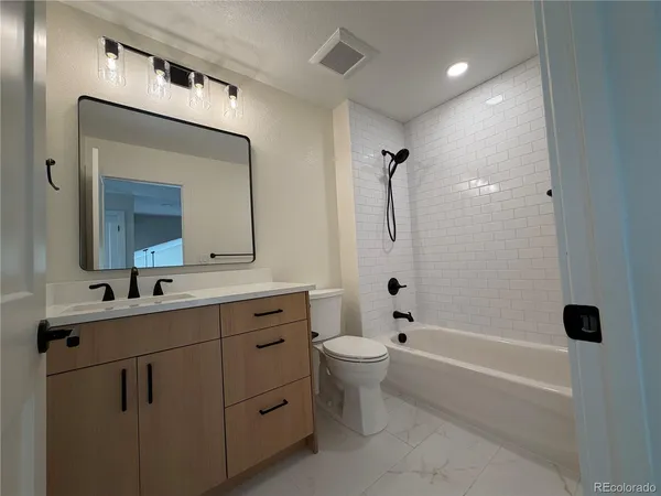 a bathroom with a double vanity sink toilet mirror and bathtub