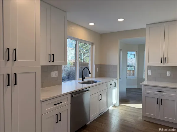 a kitchen with a sink cabinets and wooden floor