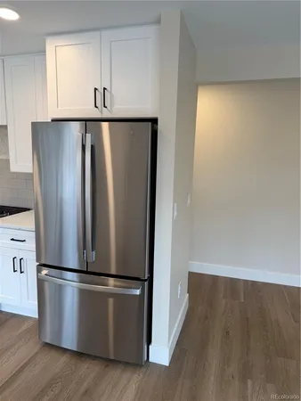 a view of a kitchen with wooden floor and stainless steel appliances