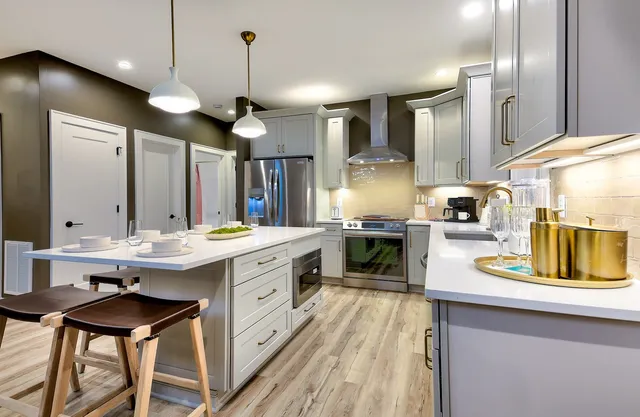 a kitchen with a sink stove and wooden floor