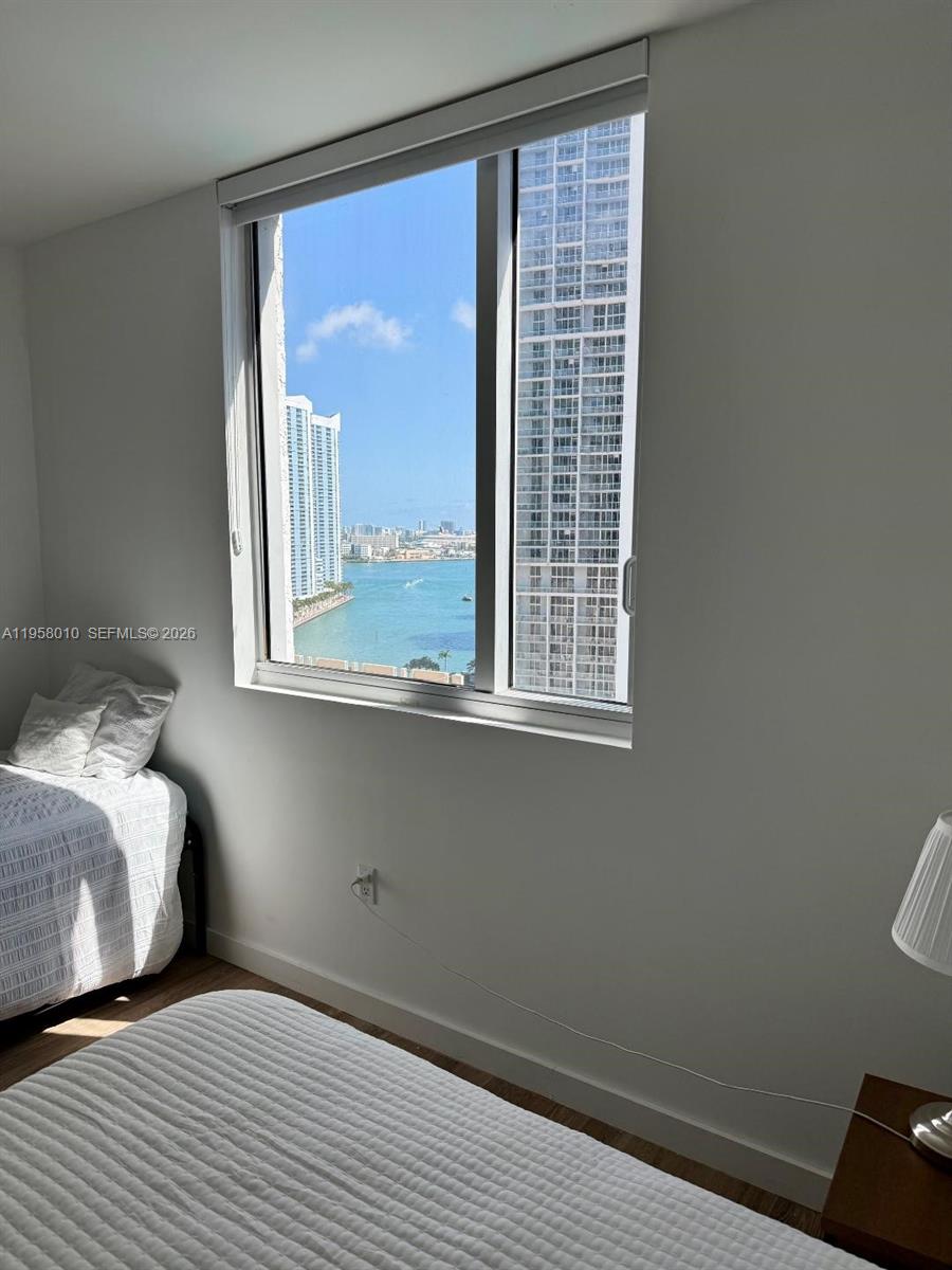 55 Southeast 6th Street, Unit 1807 Miami, FL 33131 - Photo 11 of 23 a bedroom with a bed and a window