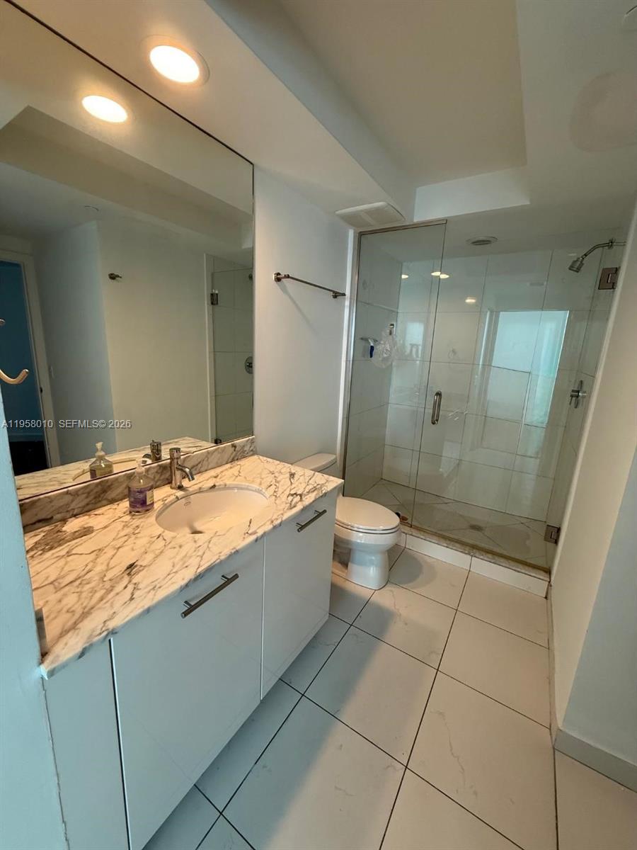 55 Southeast 6th Street, Unit 1807 Miami, FL 33131 - Photo 12 of 23 a bathroom with a granite countertop sink a toilet and shower