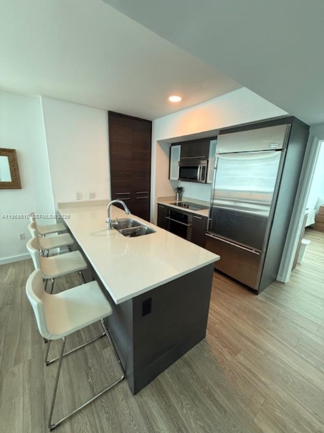 55 Southeast 6th Street, Unit 1807 Miami, FL 33131 - Photo 4 of 23 a living room with stainless steel appliances furniture and a flat screen tv