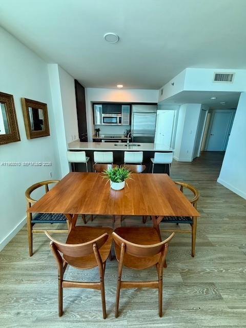 55 Southeast 6th Street, Unit 1807 Miami, FL 33131 - Photo 5 of 23 a view of a dining room with furniture and wooden floor