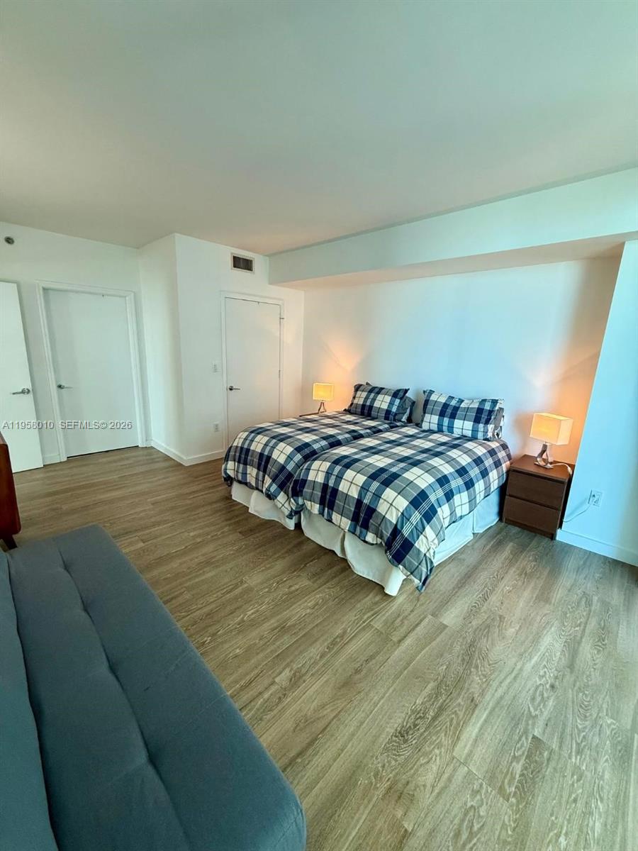55 Southeast 6th Street, Unit 1807 Miami, FL 33131 - Photo 7 of 23 a spacious bedroom with a bed and a window