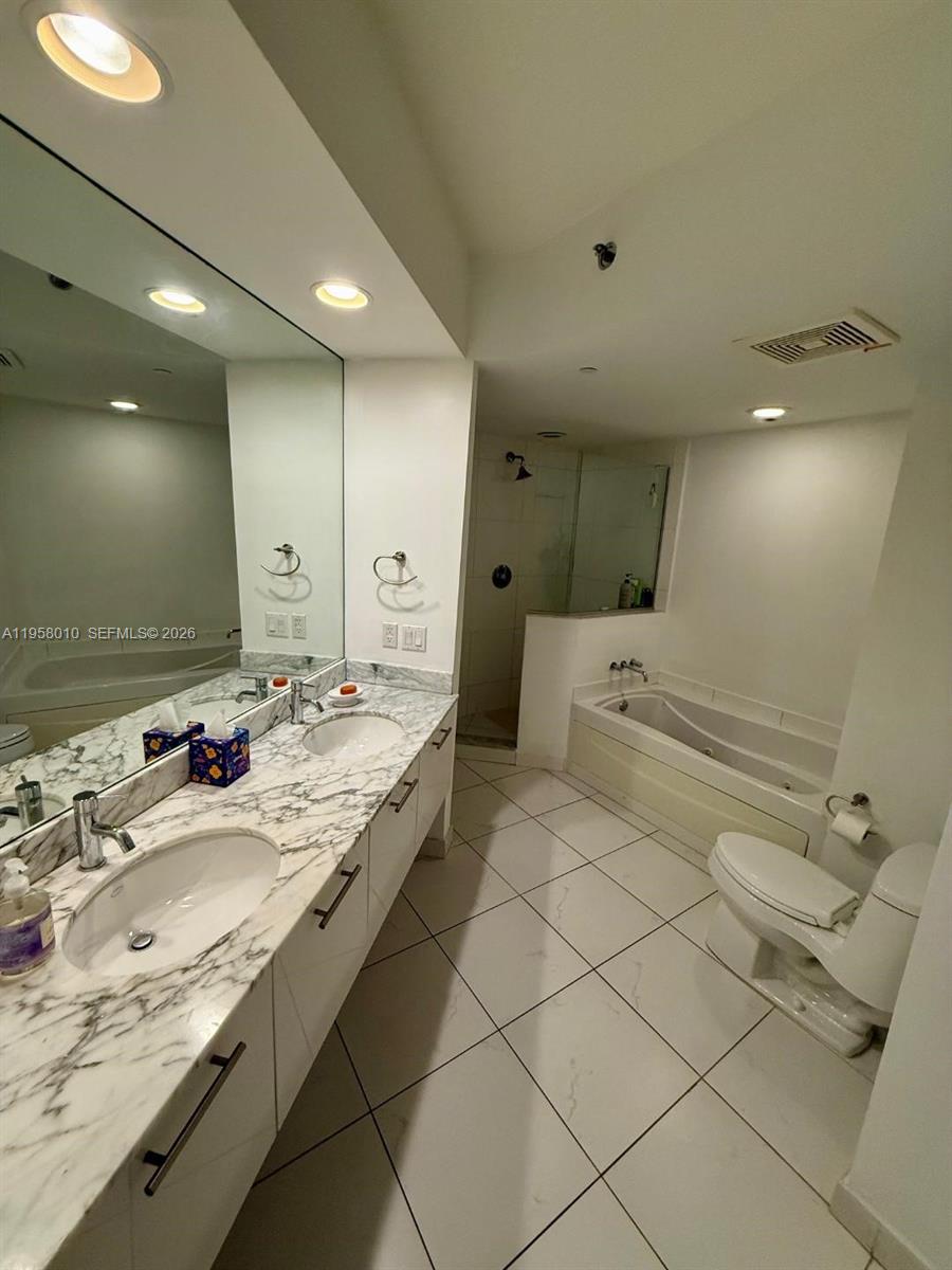55 Southeast 6th Street, Unit 1807 Miami, FL 33131 - Photo 8 of 23 a spacious bathroom with a granite countertop sink and a mirror