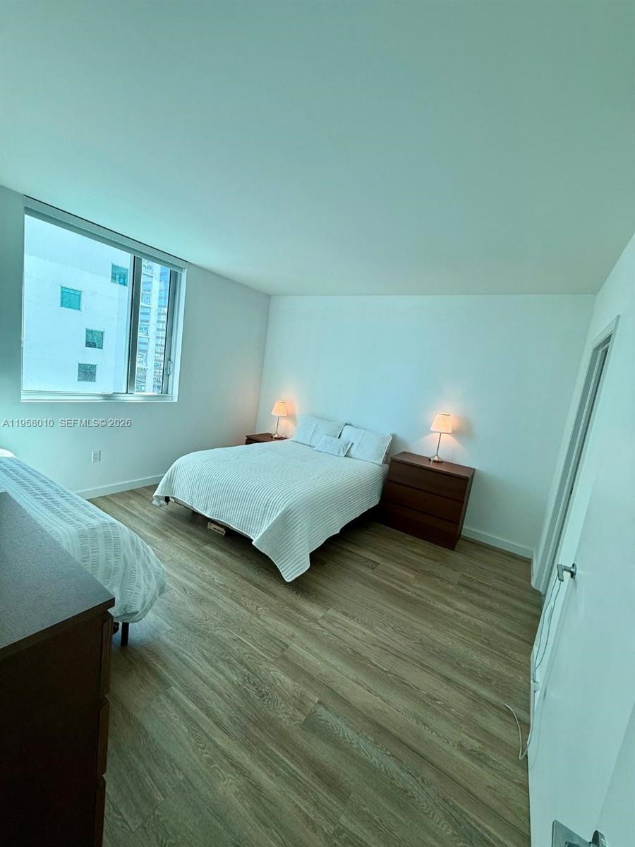 55 Southeast 6th Street, Unit 1807 Miami, FL 33131 - Photo 10 of 23 a bedroom with a bed and cabinets
