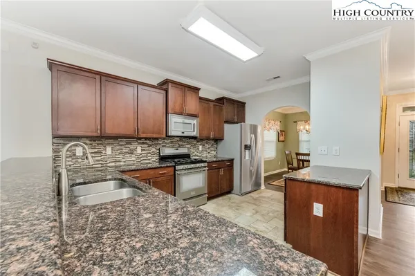 a kitchen with stainless steel appliances granite countertop a sink stove and refrigerator