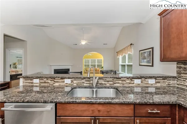 a kitchen with sink a stove and a wooden floor