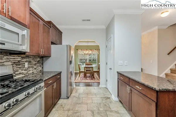 a kitchen with granite countertop a stove top oven microwave and cabinets