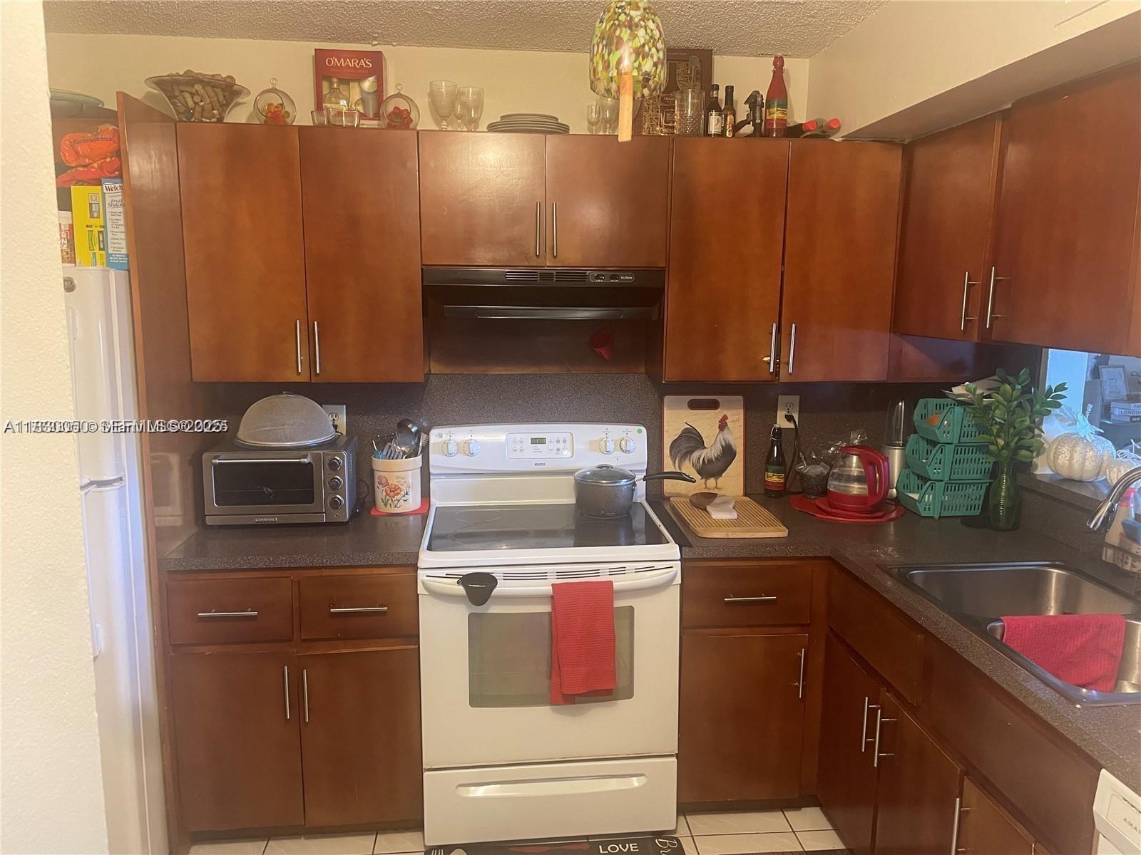 3399 Foxcroft Road, Unit 315 Miramar, FL 33025 - Photo 2 of 9 a kitchen with a stove and a microwave