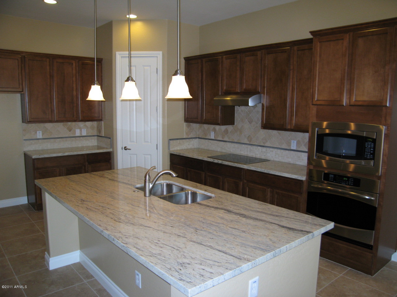 2854 East Blue Sage Road Gilbert, AZ 85297 - Photo 11 of 18 a kitchen with kitchen island a sink and wooden cabinets