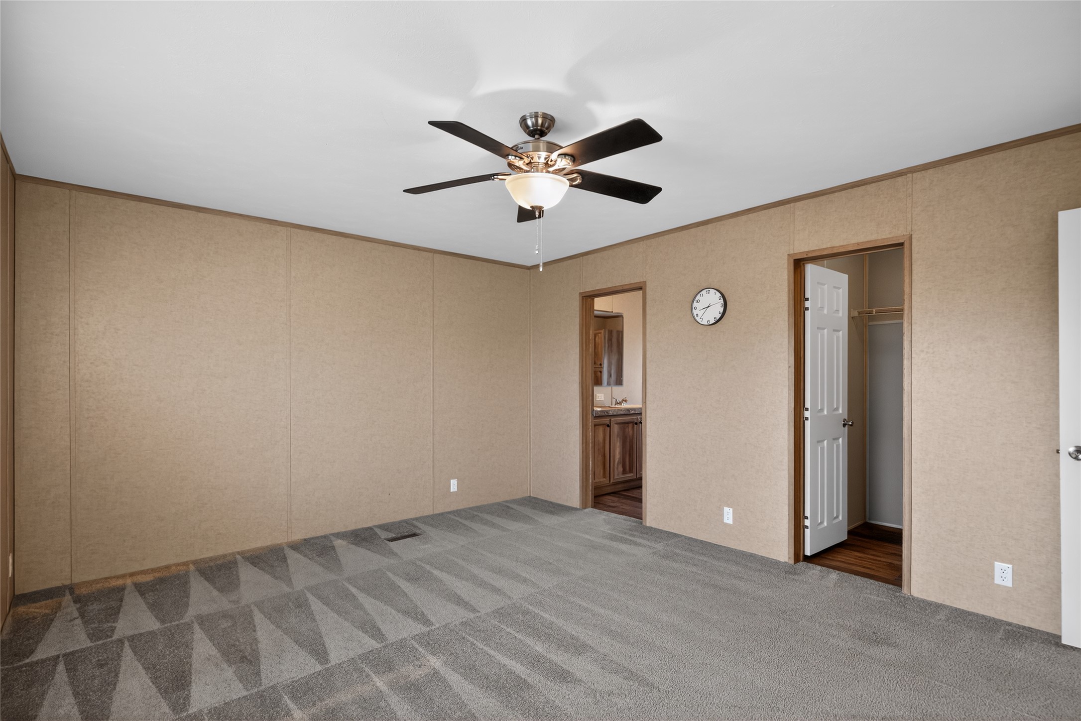 2674 Cotton Gin Road Kyle, TX 78640 - Photo 22 of 30 Unfurnished bedroom with a spacious closet, carpet floors, ceiling fan, ornamental molding, and connected bathroom
