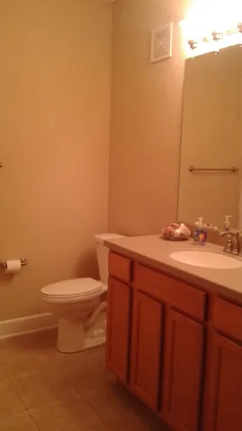 a bathroom with a granite countertop toilet and a sink