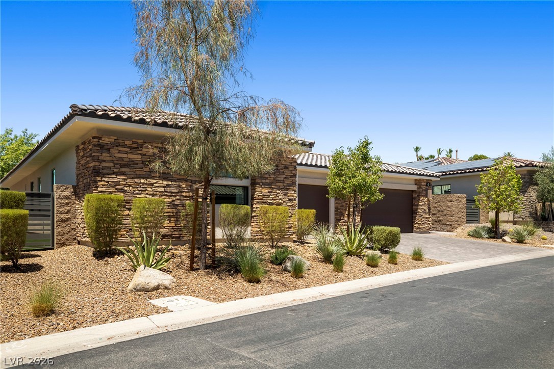 45 Garibaldi Way Henderson, NV 89011 - Photo 23 of 74 A desert-inspired landscape complements this single-story home with a tiled roof and stone veneer accents.