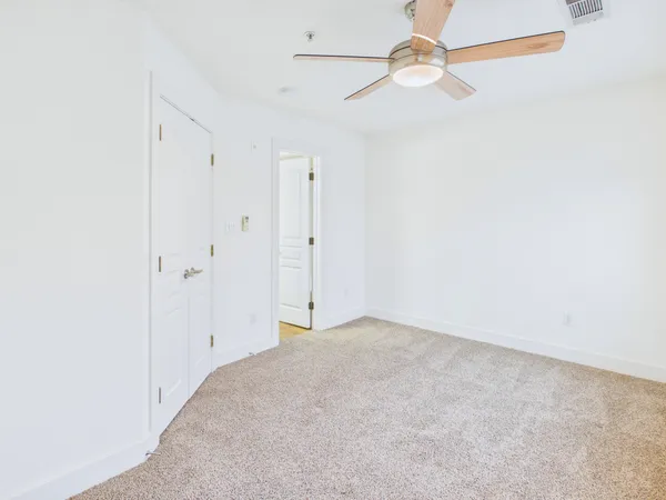 an empty room with chandelier fan