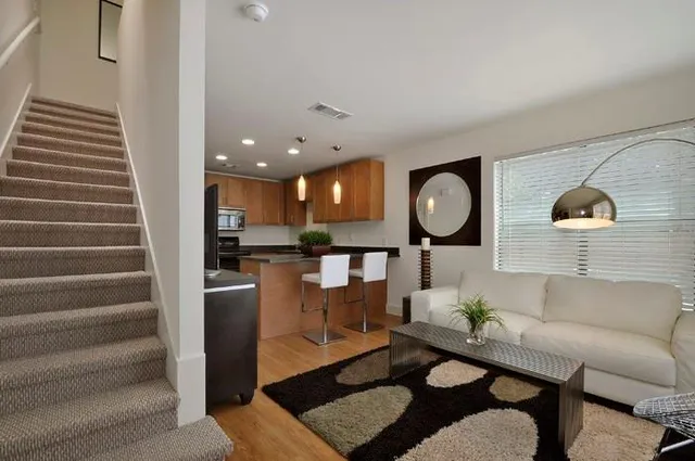a living room with furniture a window and a flat screen tv