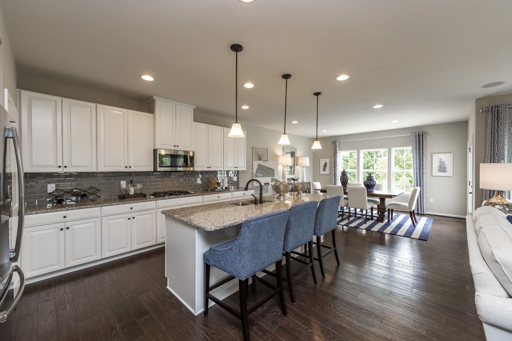 4026 Oglethorpe Drive Franklin, TN 37064 - Photo 5 of 15 a kitchen with stainless steel appliances granite countertop a stove a sink a refrigerator a dining table and chairs with wooden floor