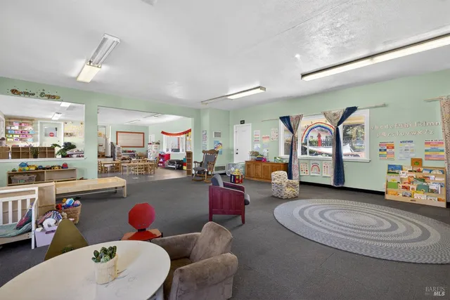 a living room with furniture a rug and white walls