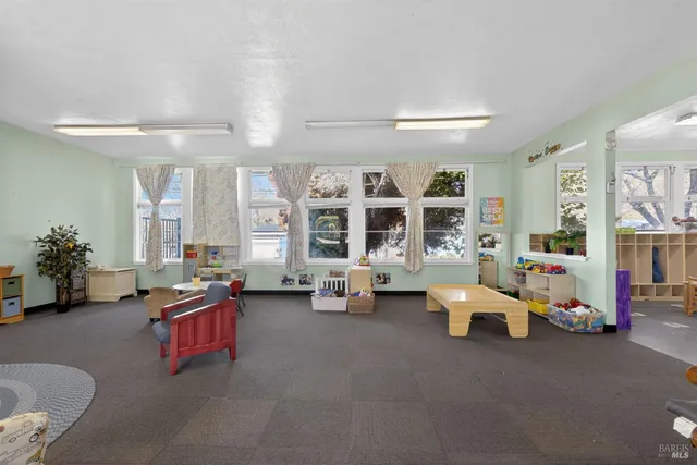 a living room with furniture a flat screen tv and a large window