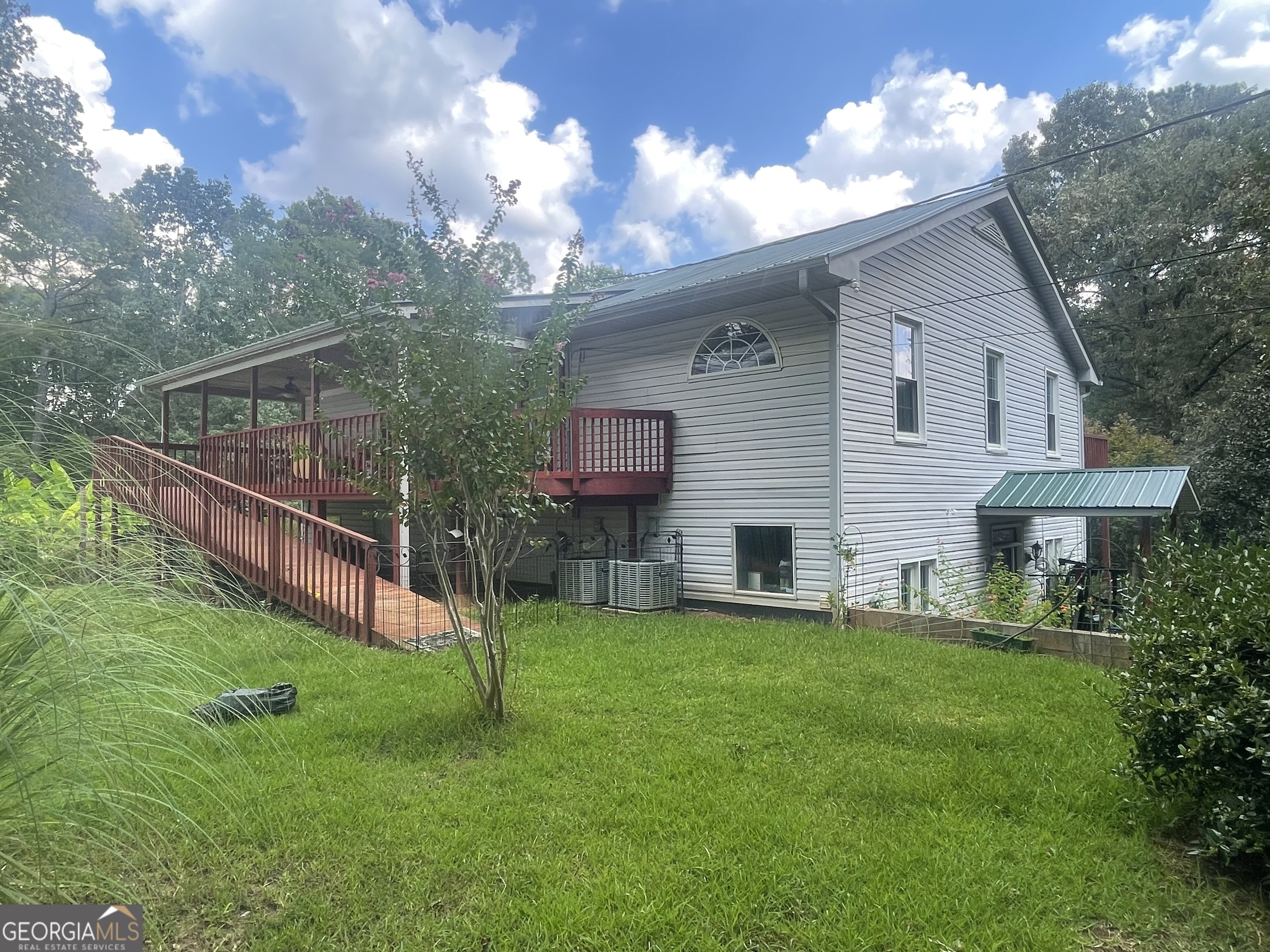a view of a house with a yard and a tree