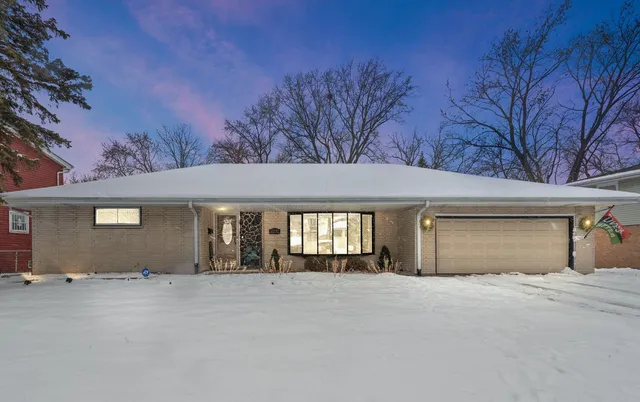 front view of a house with a yard and garage