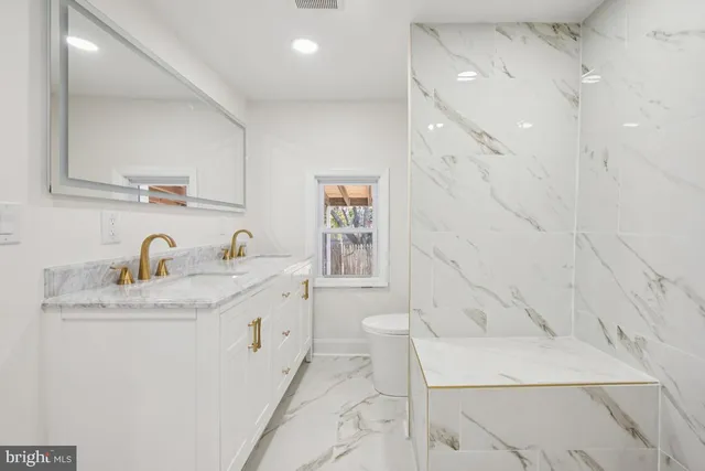 a bathroom with a granite countertop sink a toilet and bathtub