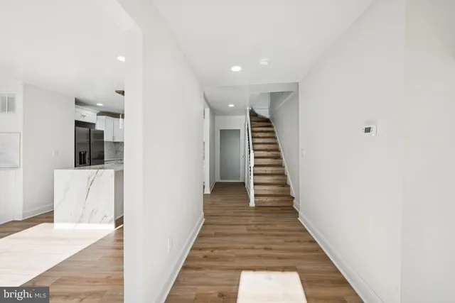 a view of a hallway with wooden floor and staircase